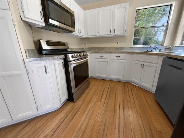 kitchen featuring white cabinets, stainless steel appliances, light hardwood / wood-style floors, and sink