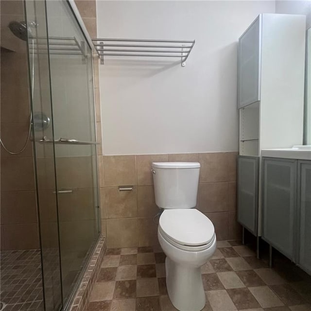 3045 Steeplechase, Alpharetta, GA 30004 - bathroom with tile walls, a stall shower, toilet, a wainscoted wall, and vanity