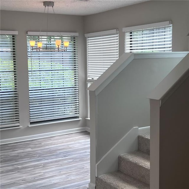 3045 Steeplechase, Alpharetta, GA 30004 - staircase featuring wood finished floors, a chandelier, a textured ceiling, and baseboards