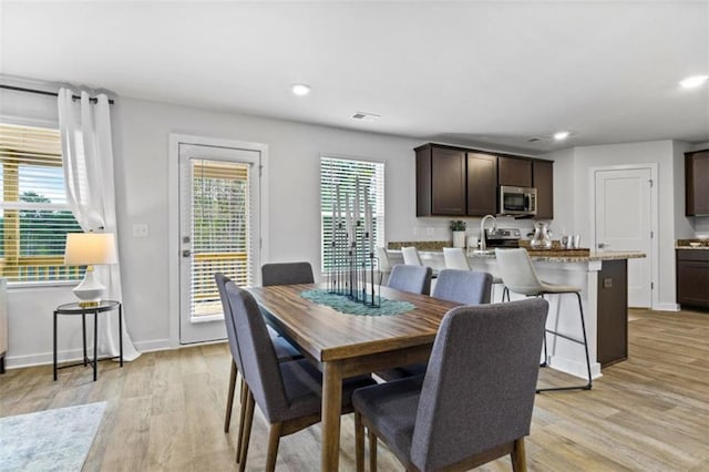 dining space featuring light hardwood / wood-style flooring and sink