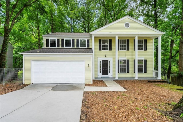1386 Heritage Glen Dr, Marietta, GA 30068 - neoclassical home featuring covered porch, concrete driveway, and view of scattered trees