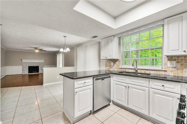 1386 Heritage Glen Dr, Marietta, GA 30068 - kitchen featuring stainless steel dishwasher, white cabinetry, light tile patterned flooring, ceiling fan, and a fireplace