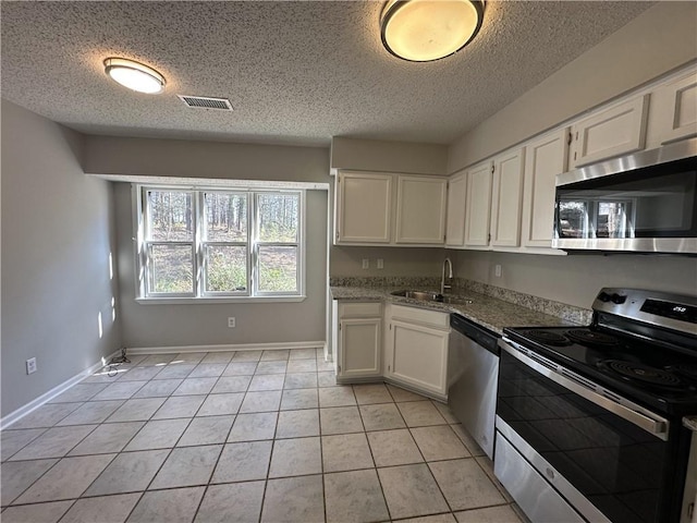 kitchen with a sink, white cabinets, visible vents, and stainless steel appliances