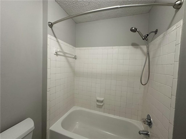 full bathroom featuring toilet, bathtub / shower combination, and a textured ceiling