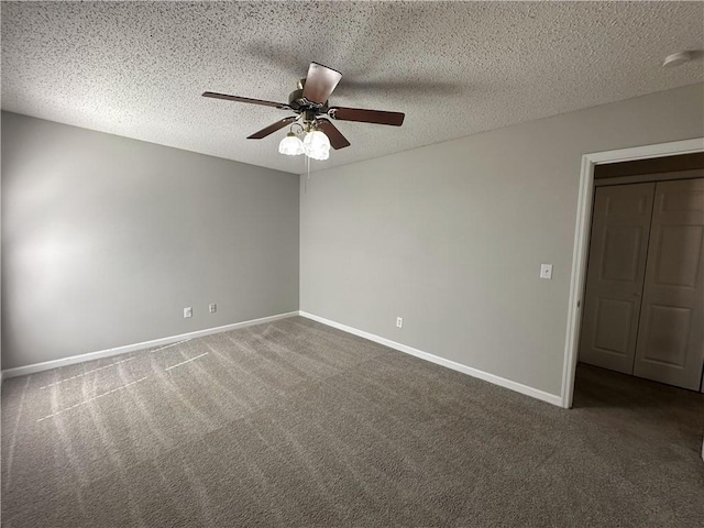 carpeted empty room with baseboards, a textured ceiling, and a ceiling fan