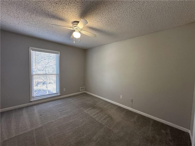 unfurnished room with a textured ceiling, baseboards, dark carpet, and ceiling fan