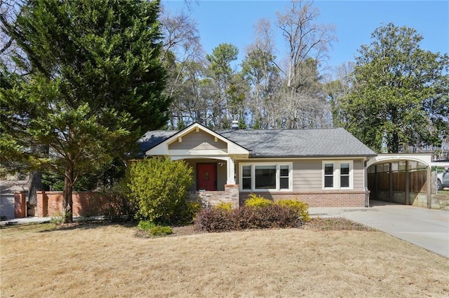 view of front facade featuring a front lawn, driveway, a carport, fence, and brick siding