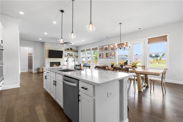 kitchen with white cabinetry, stainless steel dishwasher, dark wood-type flooring, and an island with sink