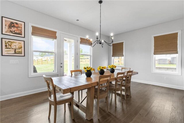 dining space with a chandelier and dark hardwood / wood-style flooring