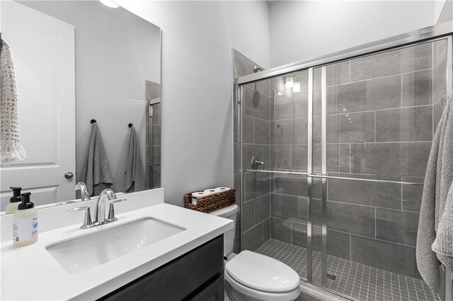 bathroom with toilet, walk in shower, and vanity