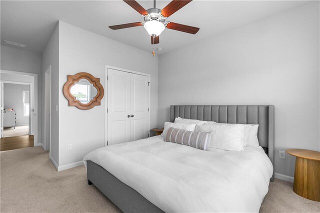 carpeted bedroom with a closet and ceiling fan