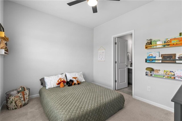 bedroom featuring light carpet, connected bathroom, and ceiling fan