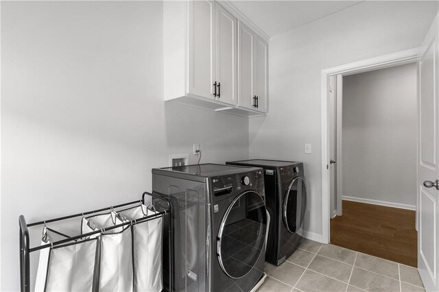 laundry room with cabinets, independent washer and dryer, and light tile patterned flooring