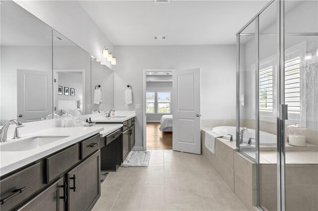 bathroom with vanity, a wealth of natural light, tile patterned flooring, and plus walk in shower