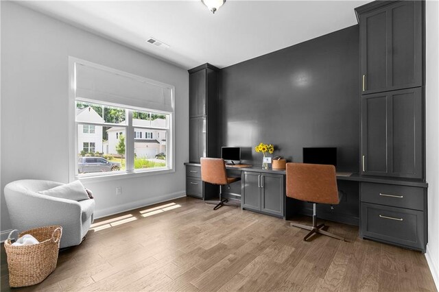 office space featuring light hardwood / wood-style flooring and built in desk