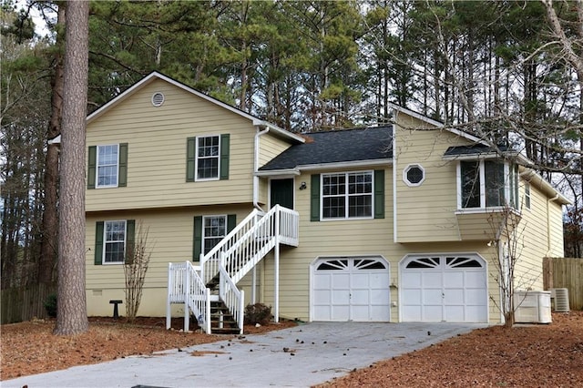 split level home featuring a garage and cooling unit