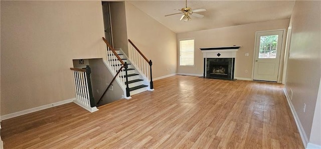 unfurnished living room featuring ceiling fan, lofted ceiling, and light hardwood / wood-style floors