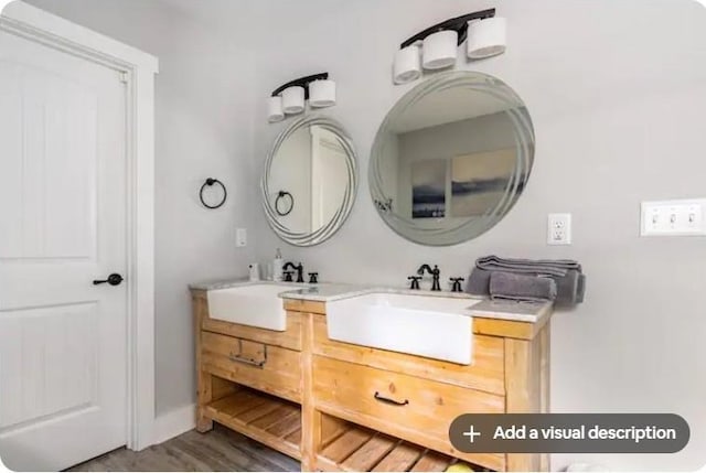 bathroom with double vanity and hardwood / wood-style flooring