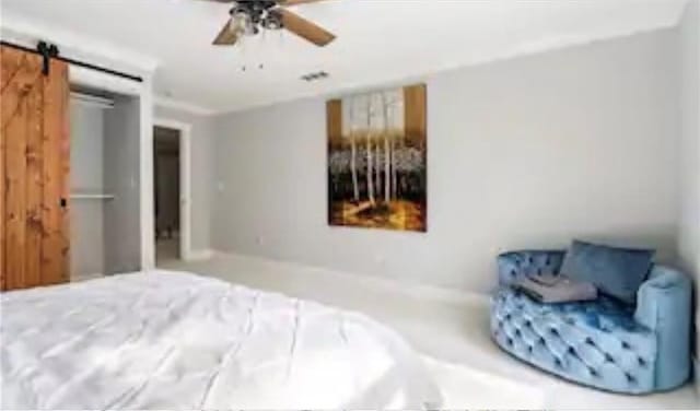 bedroom featuring a barn door and ceiling fan