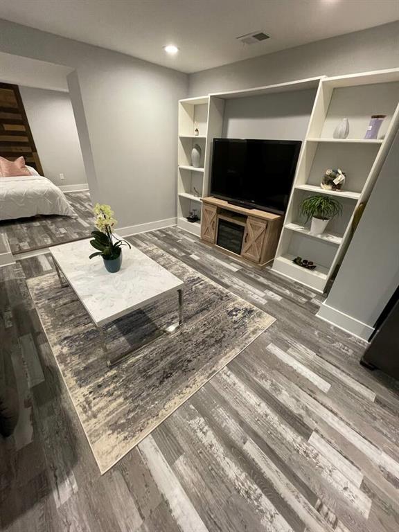 living room featuring dark hardwood / wood-style floors and built in shelves