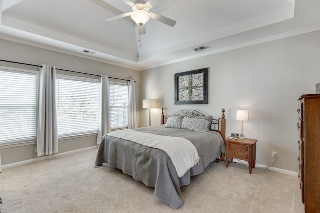 carpeted bedroom featuring a tray ceiling, ceiling fan, and ornamental molding