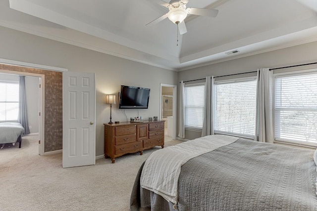 bedroom with ceiling fan, a raised ceiling, light colored carpet, and multiple windows