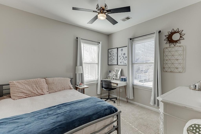 bedroom with light carpet, multiple windows, and ceiling fan