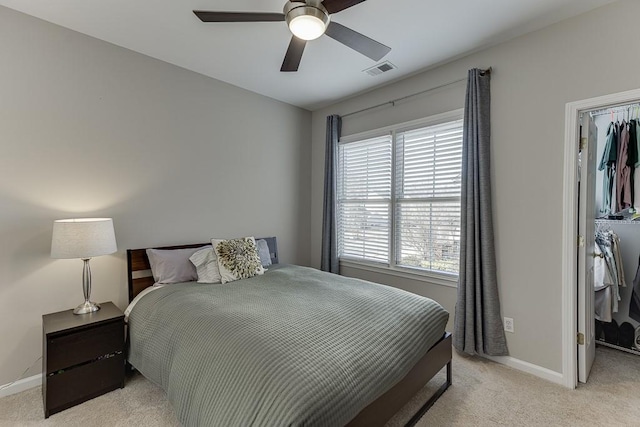 bedroom featuring ceiling fan, light colored carpet, and multiple windows