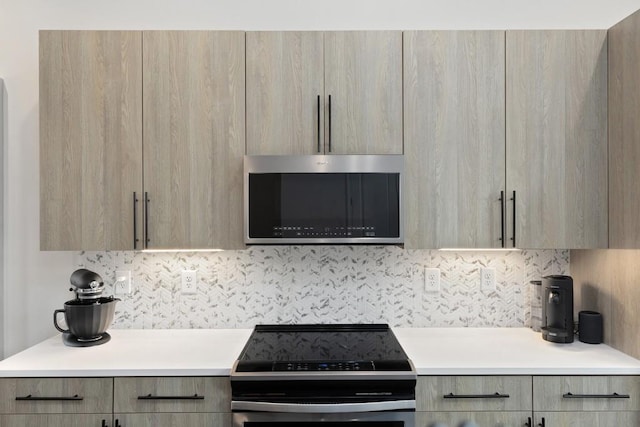 kitchen featuring light brown cabinetry, backsplash, and appliances with stainless steel finishes