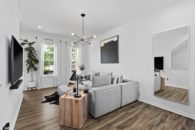 living room with a notable chandelier and dark hardwood / wood-style flooring