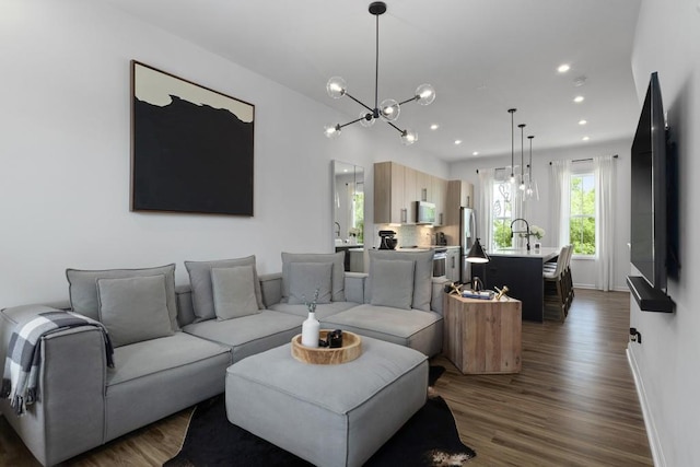 living room with a chandelier and dark hardwood / wood-style flooring