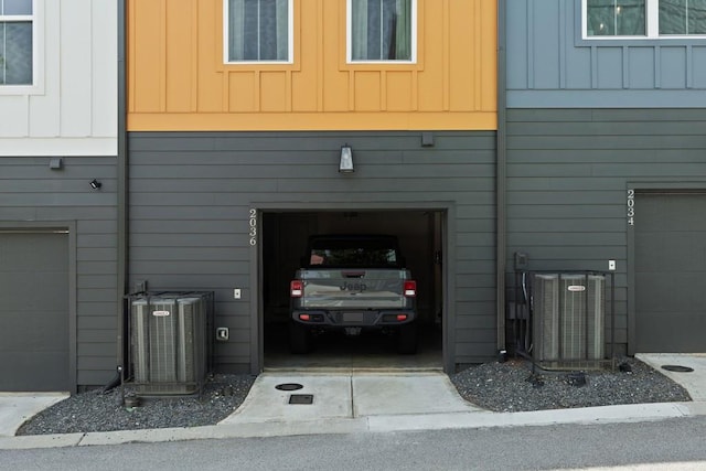 exterior space with a garage and central AC unit