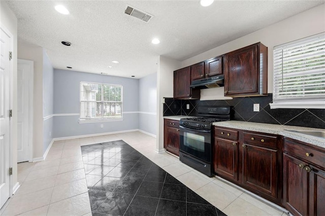 1486 Rogers Crossing Dr, Lithonia, GA 30058 - kitchen with black gas range, under cabinet range hood, recessed lighting, decorative backsplash, and light countertops