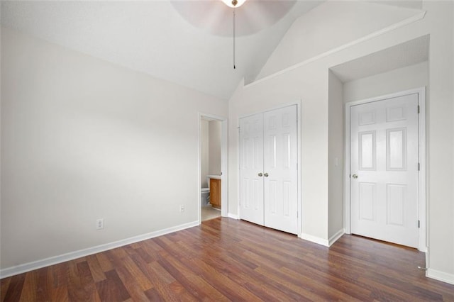 1486 Rogers Crossing Dr, Lithonia, GA 30058 - unfurnished bedroom featuring dark wood-type flooring, lofted ceiling, a closet, and baseboards