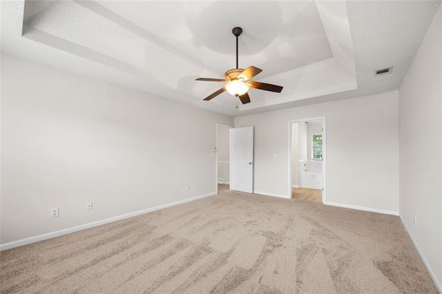 1486 Rogers Crossing Dr, Lithonia, GA 30058 - unfurnished bedroom with a tray ceiling, carpet flooring, baseboards, ensuite bathroom, and a ceiling fan