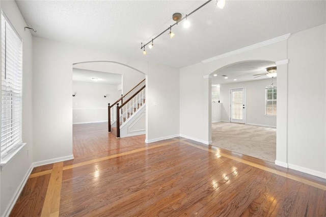 1486 Rogers Crossing Dr, Lithonia, GA 30058 - empty room featuring arched walkways, a ceiling fan, hardwood / wood-style flooring, a textured ceiling, and stairway