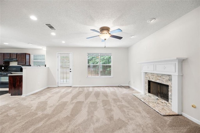 1486 Rogers Crossing Dr, Lithonia, GA 30058 - unfurnished living room featuring light colored carpet, a ceiling fan, recessed lighting, a textured ceiling, and a fireplace with raised hearth