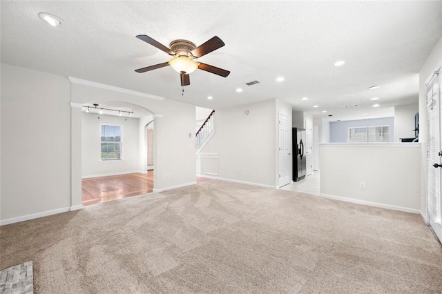 1486 Rogers Crossing Dr, Lithonia, GA 30058 - unfurnished living room with ceiling fan, light carpet, arched walkways, stairs, and recessed lighting