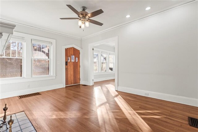 interior space with ceiling fan, wood-type flooring, and crown molding