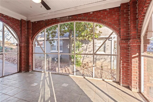 unfurnished sunroom featuring ceiling fan