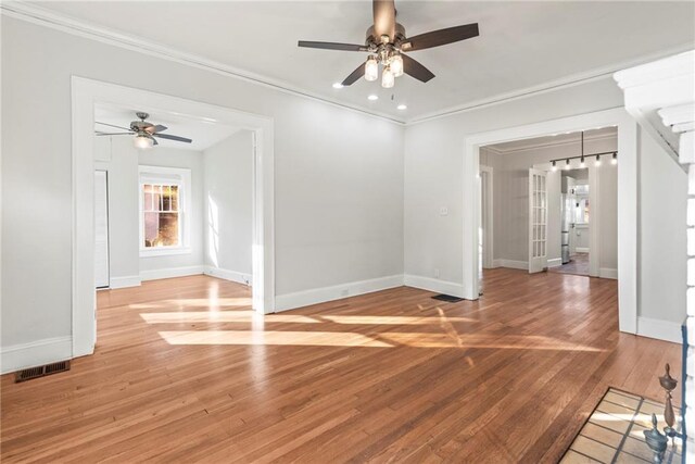 empty room featuring wood-type flooring, ceiling fan, and ornamental molding