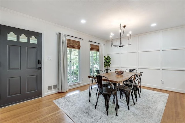 dining room featuring an inviting chandelier, crown molding, and light hardwood / wood-style flooring