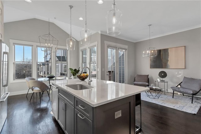 kitchen with sink, a kitchen island with sink, dark hardwood / wood-style floors, a notable chandelier, and decorative light fixtures