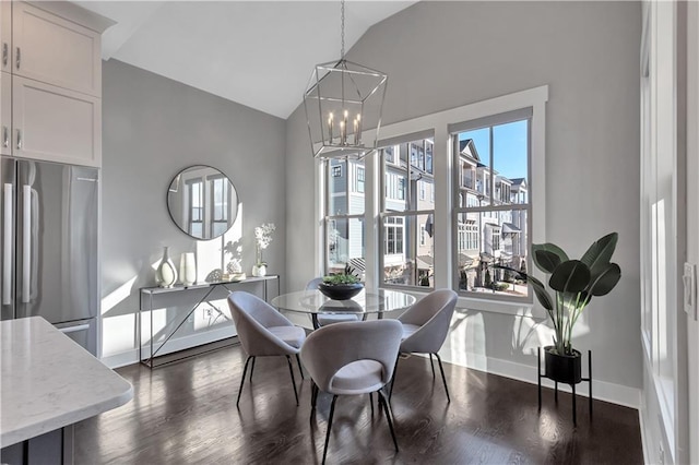 dining area with vaulted ceiling, dark hardwood / wood-style floors, and a notable chandelier