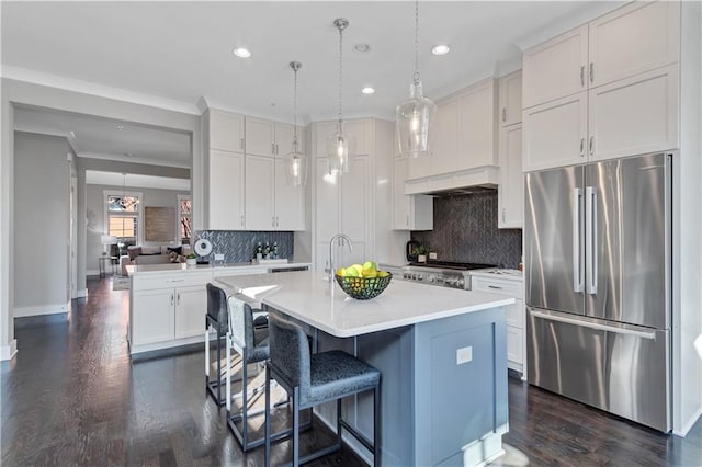 kitchen with white cabinetry, stainless steel fridge, and a center island with sink