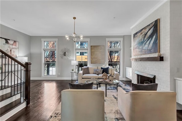 living room with a chandelier, dark hardwood / wood-style floors, a wealth of natural light, and a fireplace