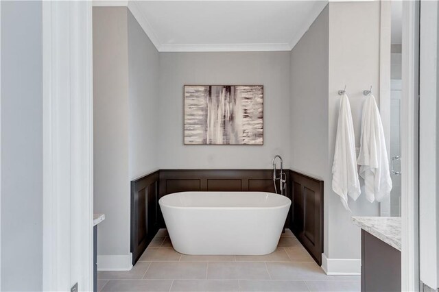 bathroom with ornamental molding, vanity, tile patterned flooring, and a bathtub