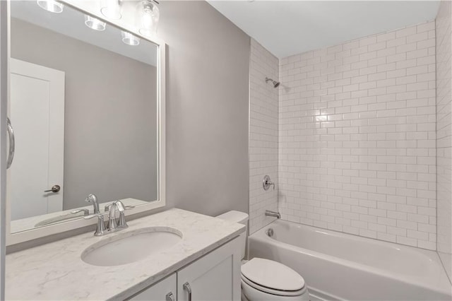 full bathroom featuring vanity, tiled shower / bath combo, and toilet