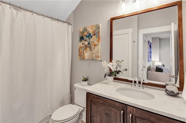 bathroom with vanity, lofted ceiling, and toilet