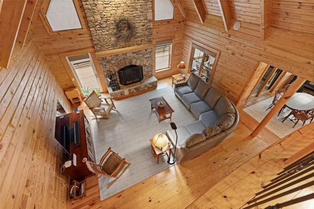 5505 Whitehall Rd, Lula, GA 30554 - unfurnished living room featuring a stone fireplace, beamed ceiling, wood walls, and hardwood / wood-style floors